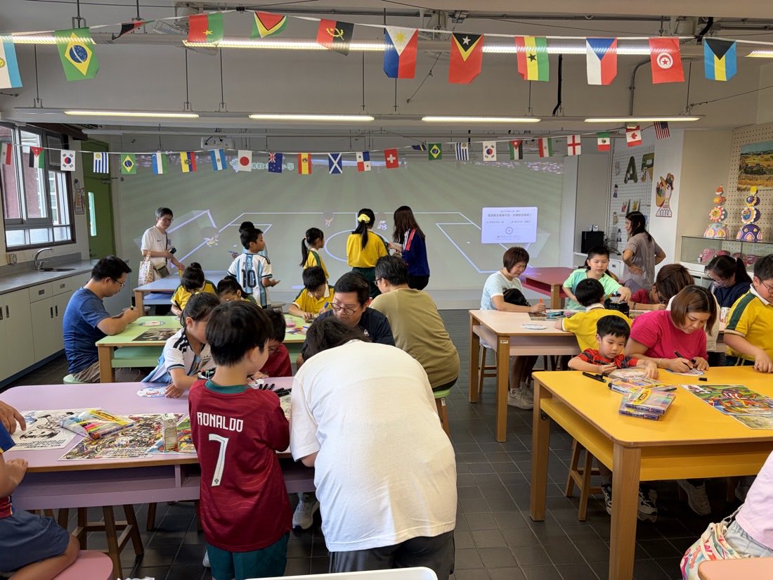 Doodle Cup event day: students and parents creating together in the classroom, with the projected pitch behind them